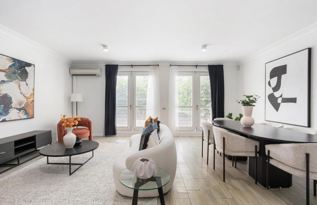 Modern styled dining and kitchen, staged property, white walls with black contrasting table. Black curtain windows.