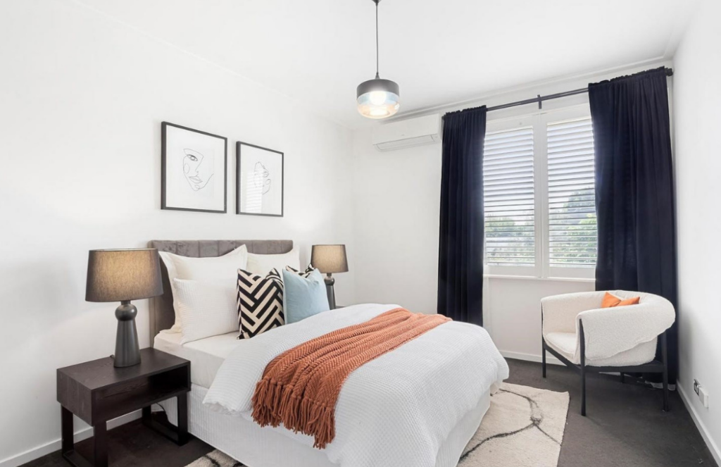 warm and cozy main bedroom in hawthorn. Staged bedroom, white walls with colourful cushions and accessories. 3122