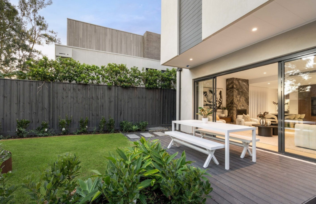 modernised gardens with outdoor table stage setting in Glen Iris. Wide open inviting doors showcasing a warm main living room.