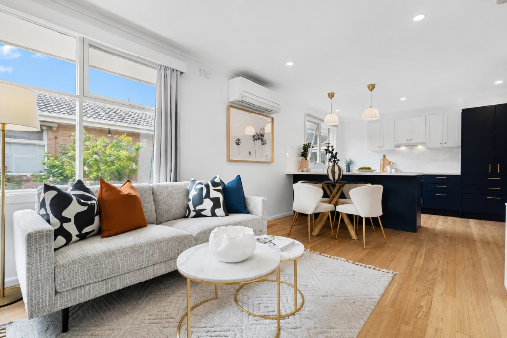 a stunning staged unit lounge room with white walls and warm colours.