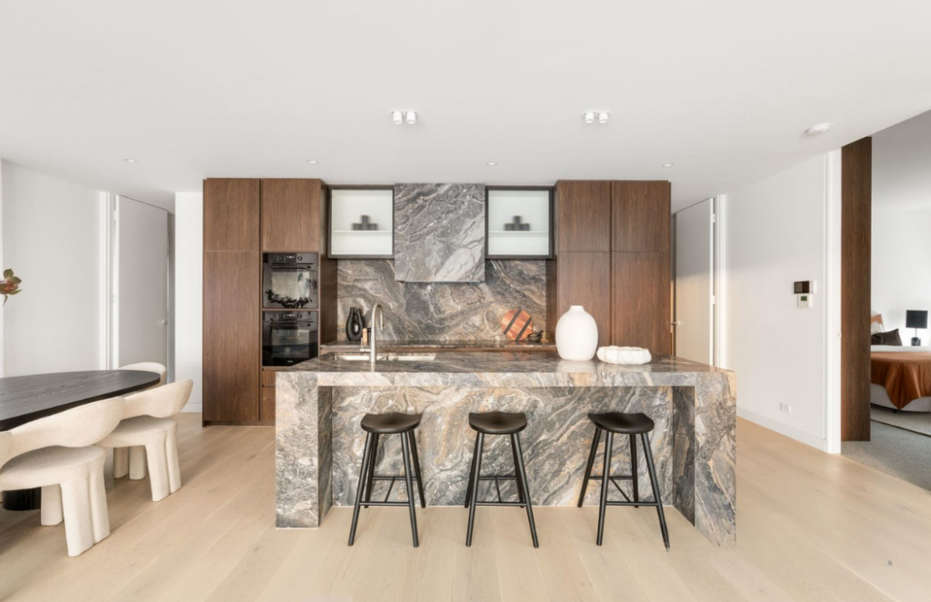 Dark modern styled kitchen, dark earthy marble island bench with contrasting black stools in Glen iris.