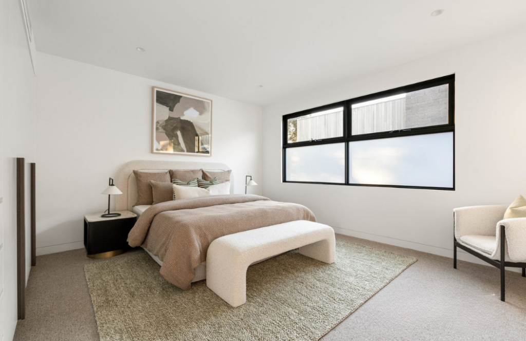 Glen Iris main bedroom stage, Brown linen theme, white ottoman at foot of bed, large king room.