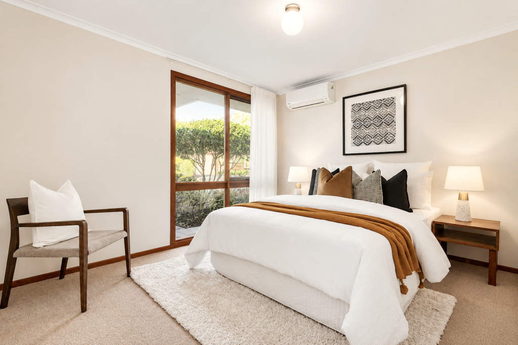 A standard bedroom in Mitcham staged with black white and rust as the main colors