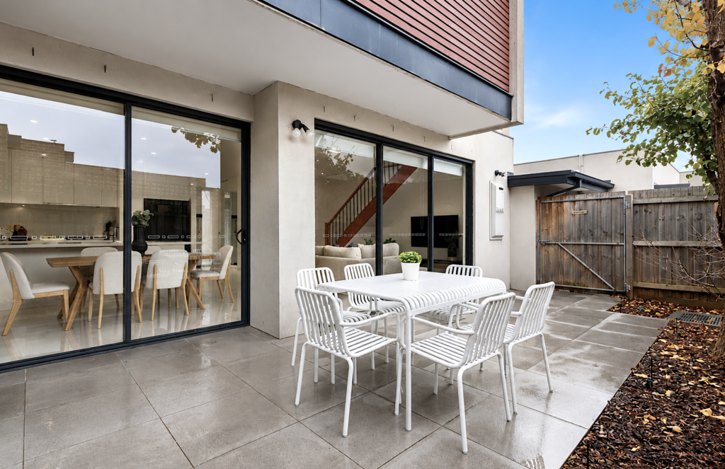 Private outdoor entertaining courtyard with modern outdoor dining setting and seamless indoor-outdoor flow in a townhouse in Carnegie.