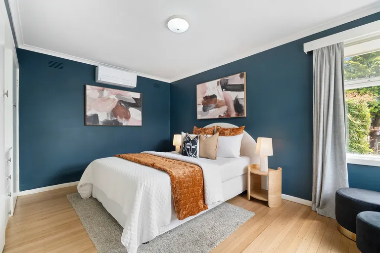 a modern staged bedroom in Murrumbeena with warm accessories and cushion colouring.