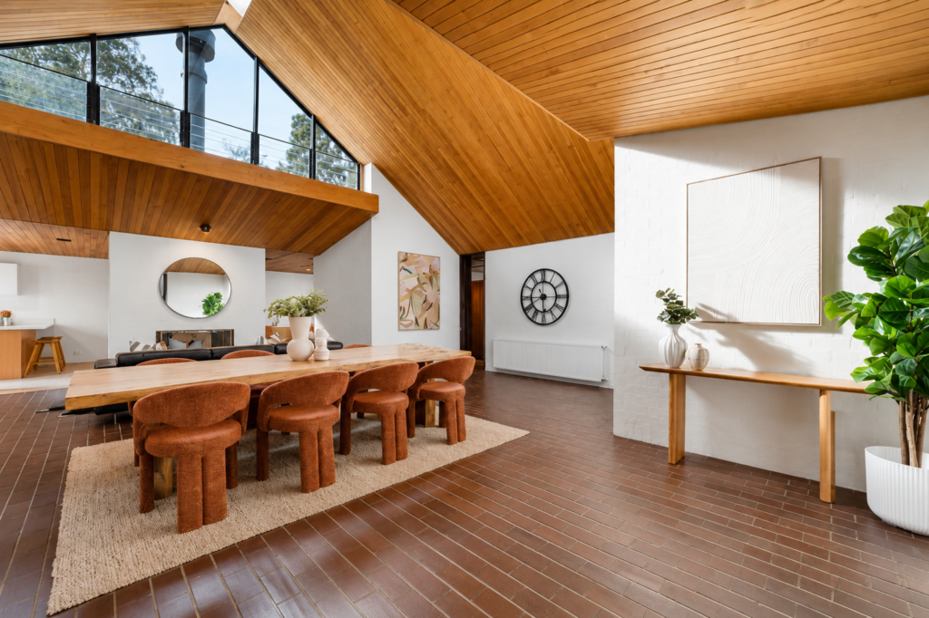 Dining room stage at blackburn, This stage has timber roofing and timber flooring, paired with an orange modern dining chairs and a large timber dining table.