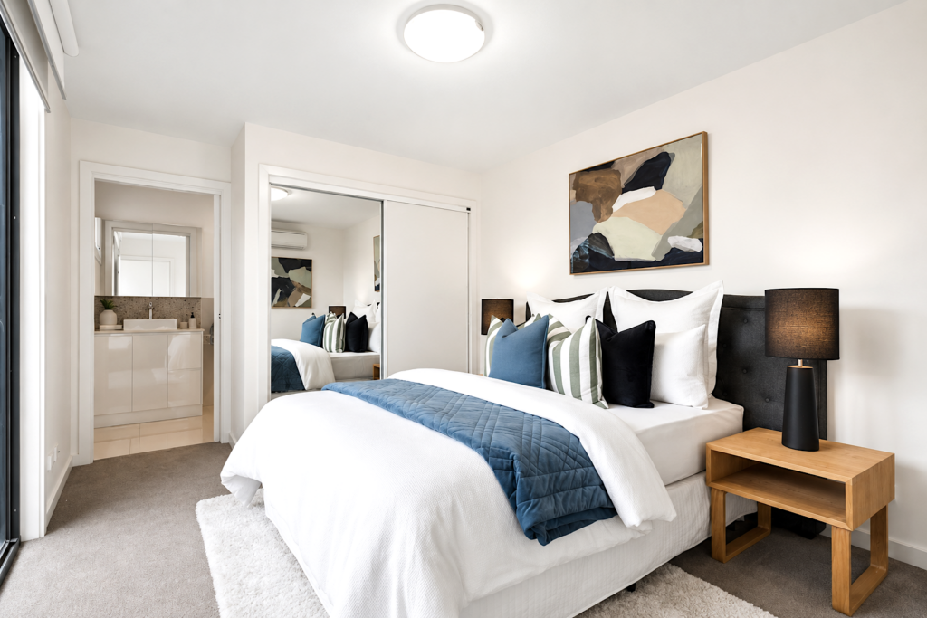 Professionally styled master bedroom with ensuite, mirrored wardrobes and contemporary furnishings in a townhouse in Carnegie.