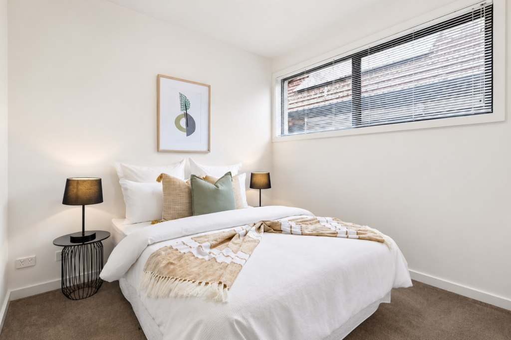Bright second bedroom with neutral styling, soft furnishings and modern décor in a townhouse in Carnegie.