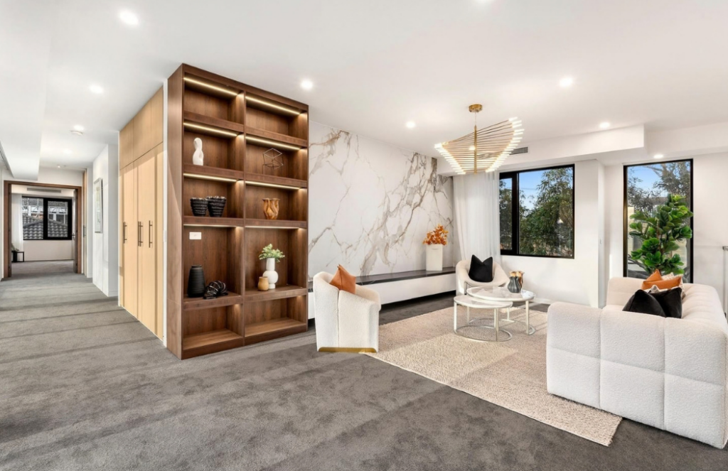 Upstairs lounge with white textured furniture, marble feature wall and built-in timber shelving in a luxury house in Doncaster.