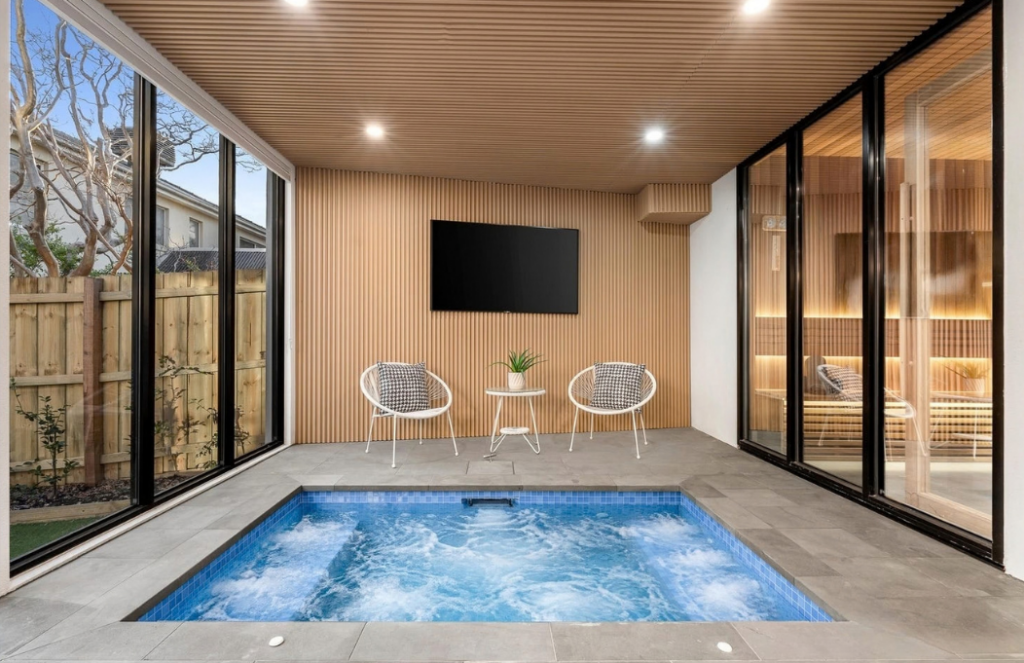 Indoor spa area with timber feature walls, seating and large glass windows in a luxury house in Doncaster.