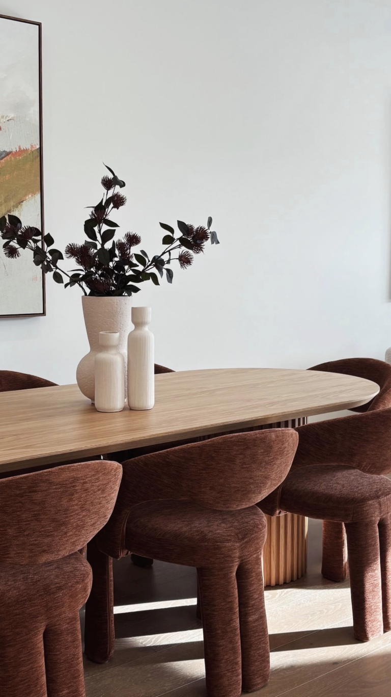 Minimalist dinning area with wooden dinning table and curved dinning chairs of the townhouse in Bentleigh
