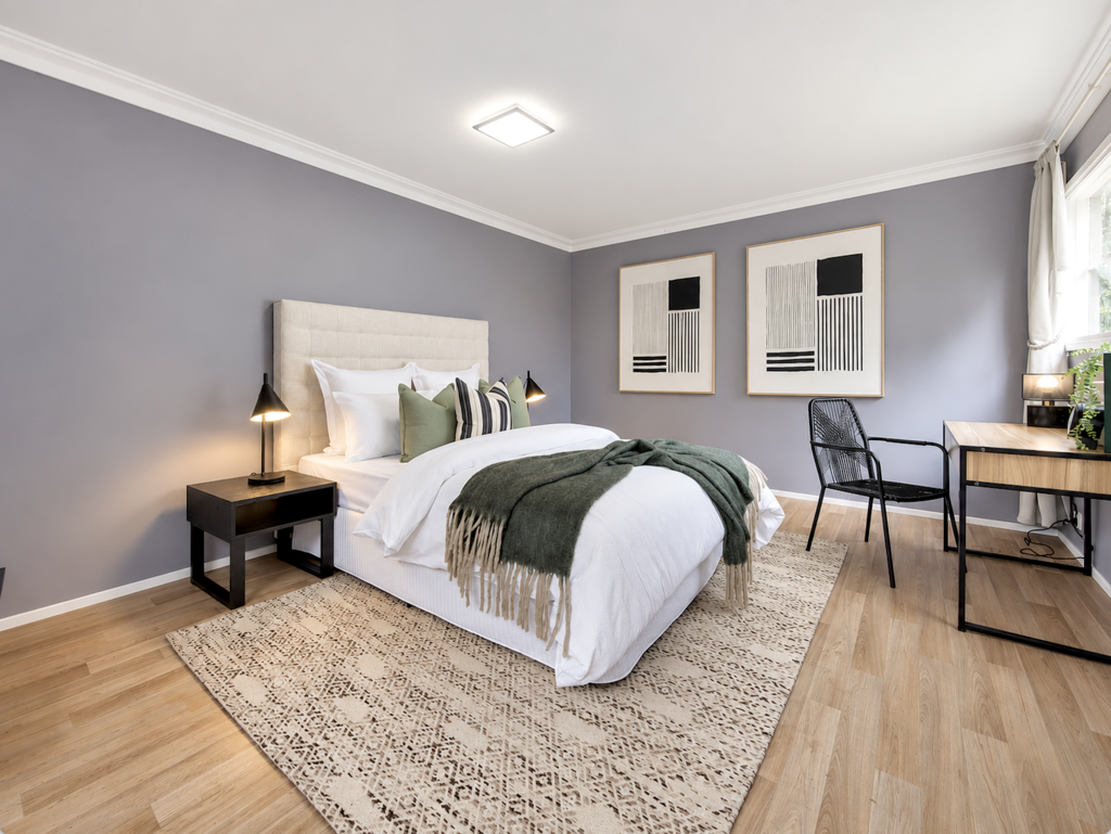 Staged bedroom with sage green accents, neutral furnishings and modern artwork in a Melbourne home