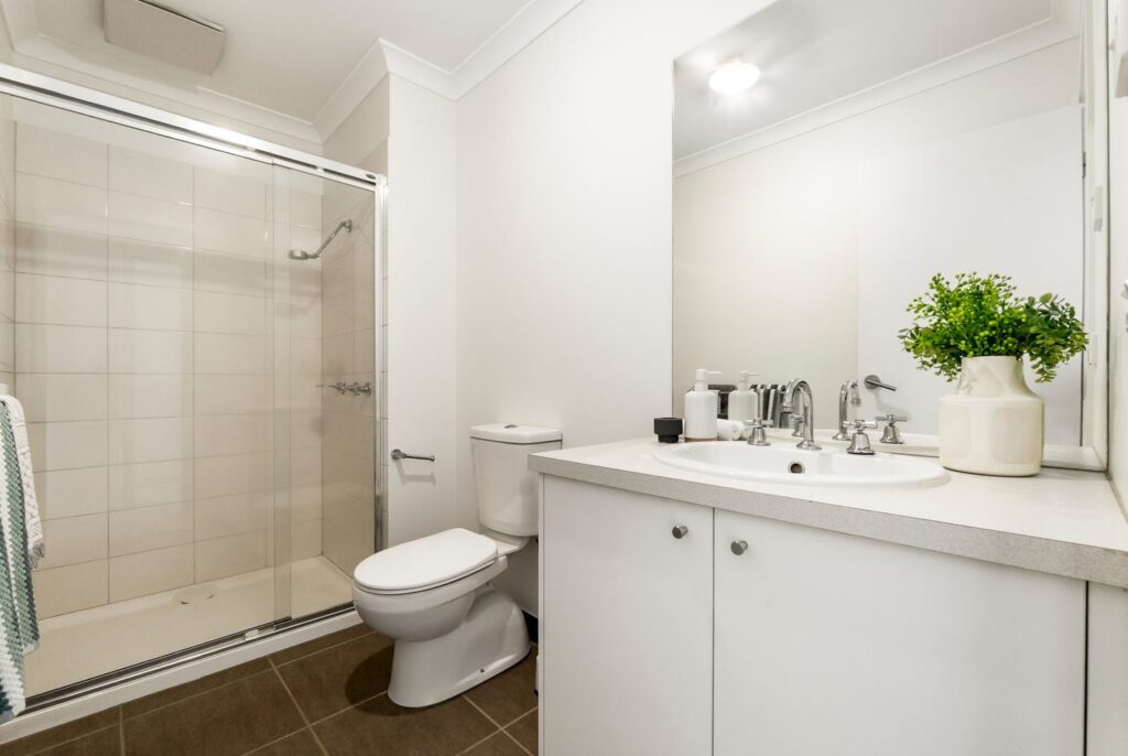 Bright bathroom styled with greenery and neutral accessories in a townhouse in Croydon